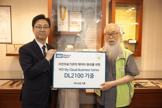 조원석 웨스턴디지털코리아 대표(왼쪽)와 이문주 요셉의원 원장이 30일 서울 영등포동 요셉의원에서 NAS(네트워크스토리지) 제품 기증식을 통해 문서 중앙화와 공유에 사용할 수 있는 마이클라우드 DL2100을 설치했다. 웨스턴디지털코리아 제공